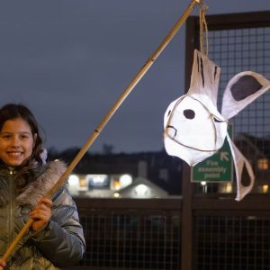 A young girl holds a hand-made, fish-shaped paper lantern made for the Harbour Lights parade in Newhaven, East Sussex.