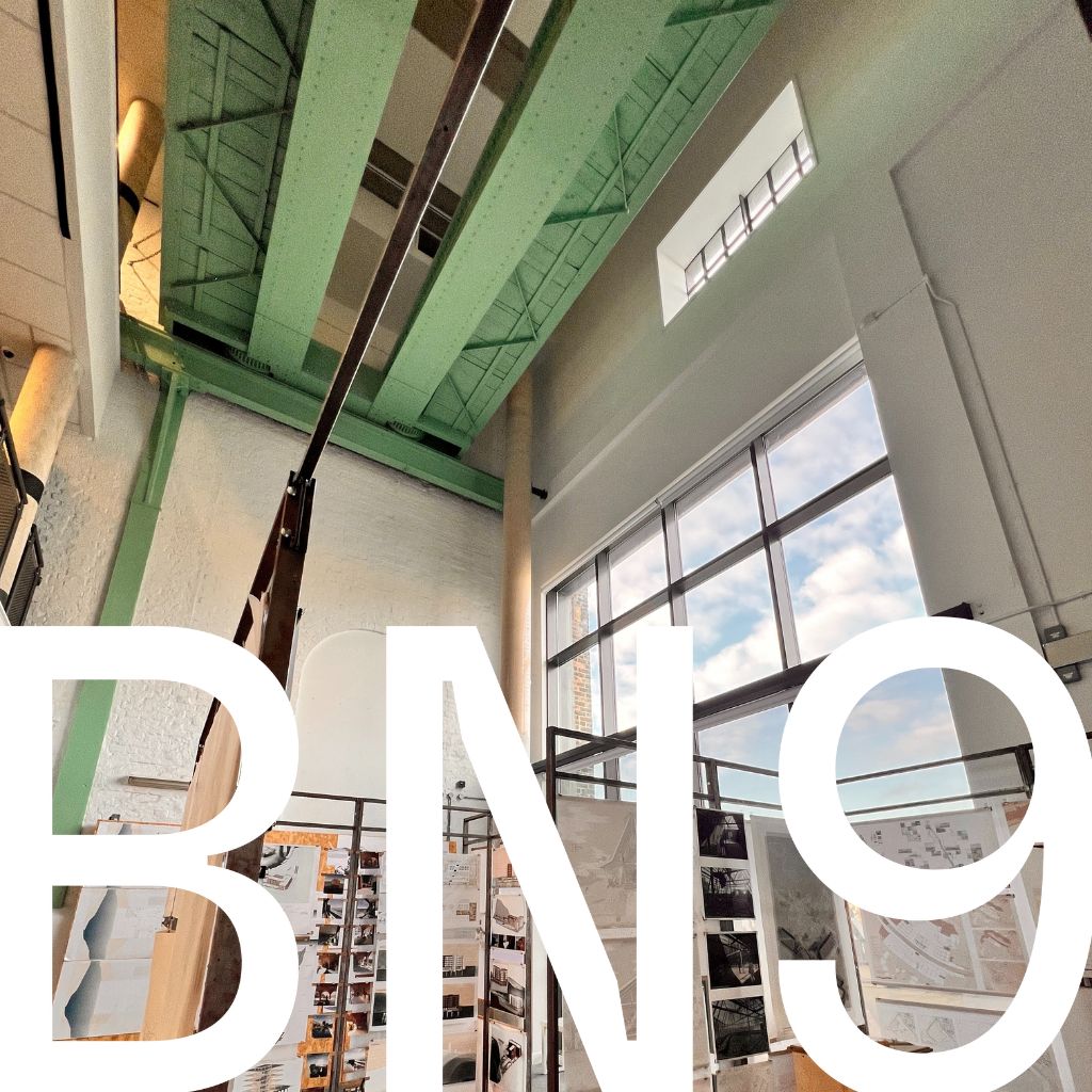 A photograph of the Atrium gallery in Newhaven's Marine Workshops, overlaid with the postal code prefix BN9 logo. The image shows the high ceilings and heavy lifting gantry in this previously industrial building.
